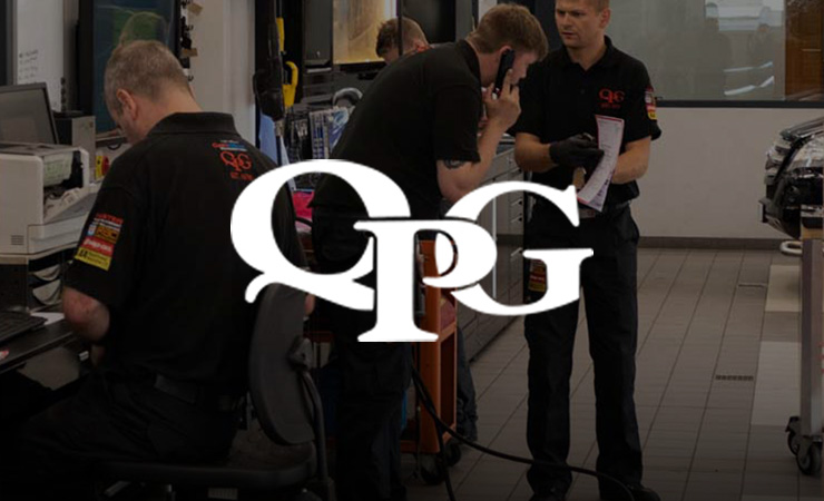 QPG logo over Queens Park Garage technicians working in the workshop